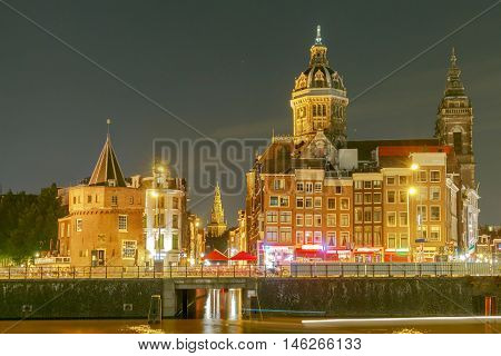 Night city view of Amsterdam canal and Basilica of Saint Nicholas Holland Netherlands.