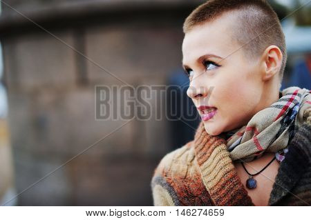 Portrait of young beautiful woman with stylish short haircut in the background of a city street close-up.