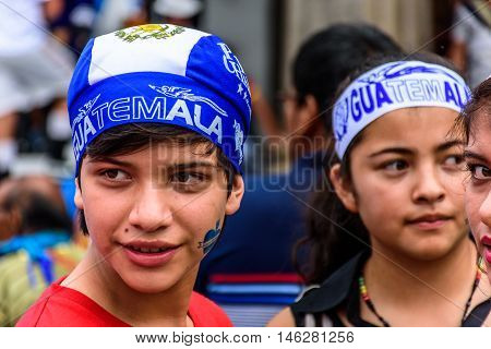 Antigua Guatemala - September 14 2015: Young patriots with patriotic headbands & Guatemalan flag stamped on their faces during Guatemalan Independence Day celebrations