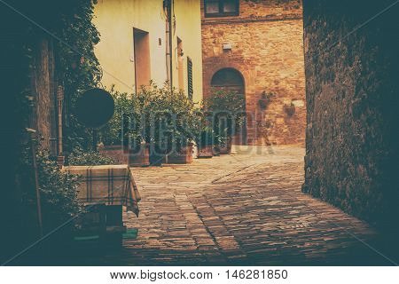 Empty street of small Tuscany town San Quirico d'Orcia in the morning fog, romantic travel vintage hipster european italy background