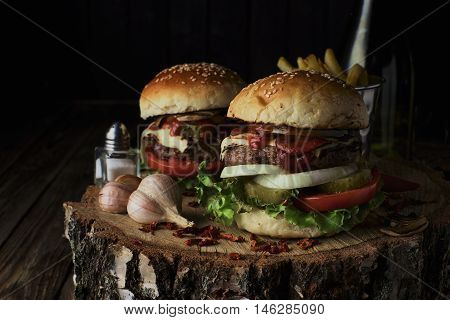 Delicious burgers in a rustic style on dark wooden background.