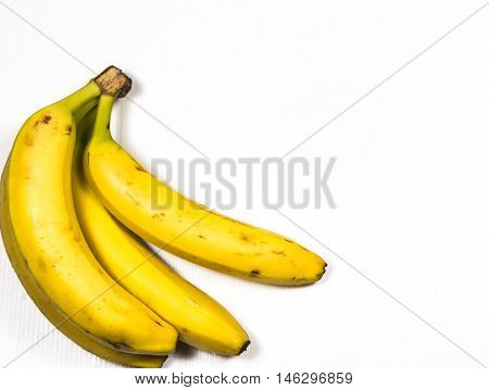 Four ripe yellow bananas on white background