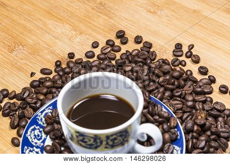 Coffee cup and coffee beans on a wooden table