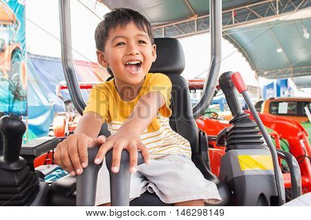 Cute little boy smile and drive tractor