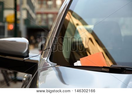 Modern car with a parking ticket on its window in New York City.