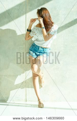 Fashion Portrait Of Young Model Posing By The Wall