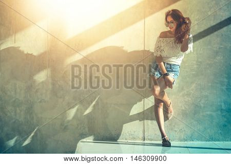 Fashion Portrait Of Young Model Posing By The Wall
