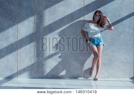 Fashion Portrait Of Young Model Posing By The Wall