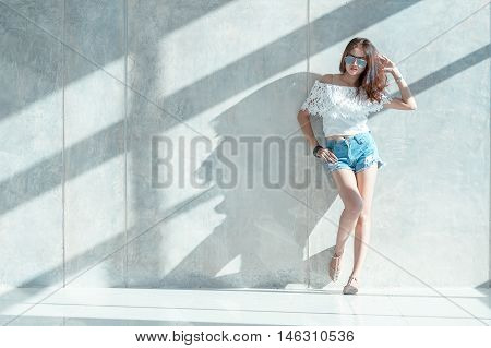 Fashion Portrait Of Young Model Posing By The Wall