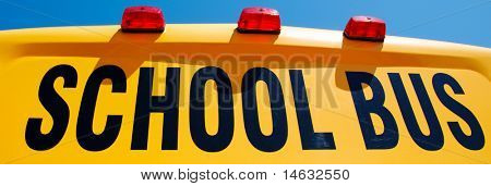 Detailní záběr žlutý školní autobus proti jasně modré obloze