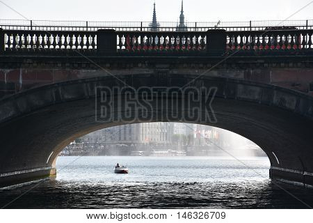 HAMBURG, GERMANY - AUG 26: Bridge on Lake Alster in Hamburg, Germany, as seen on Aug 26, 2016. Hamburg was founded at the mouth of Alster river in the 9th century and has been used as a port since.