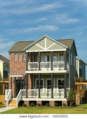 Beautiful multi-level home, property or real esate with classic or retro styling, with porches against a blue sky - space for copy above home