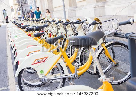 MILAN, ITALY - AUGUST 15, 2016: Bikes parked in racks to be used as public sharing service. Named BikeMi, it s the first example in the world of an integrated bike sharing system.