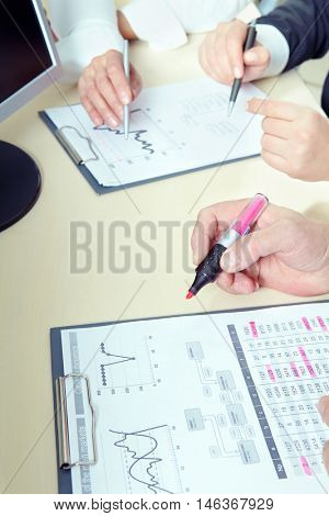 Closeup of human hand with textmarker highlighting text