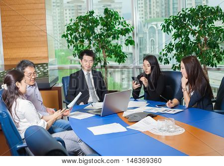 Business meeting Asian people sitting for table with business plan on high floor in the office. Asian nationality male and woman
