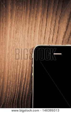 Milan Italy - September 3 2014: Apple iphone 4 smartphone on a wood surface front view from above