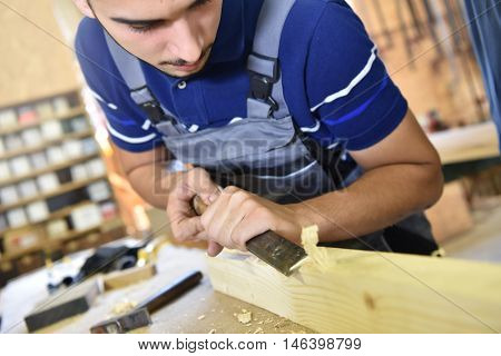 Young man in woodwork crafstmanship school, training course