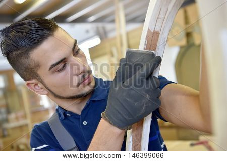 Young man in woodwork crafstmanship school, training course