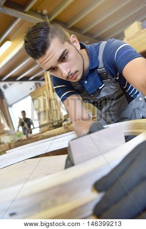 Young man in woodwork crafstmanship school, training course