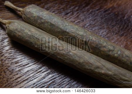 stock of hand made marijuana joints on wooden platter ashtray