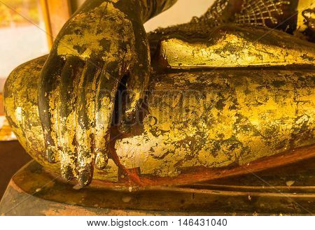 Close up hand of Buddha with gold stick plate
