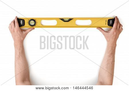 Close-up view of man's hands holding yellow building level isolated on white background. Building and construction. Repairing. DIY concept.