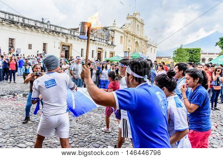 Antigua Guatemala - September 14 2015: Locals run with lit torch in front of cathedral during Guatemalan Independence Day celebrations