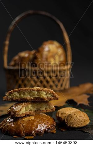 Typical Dutch filled spicy cookies with almonds on autumn colored and dark background