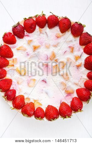 Cake with strawberries gelly yogurt and cherries isolated on white background. Shot from above