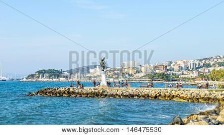 Kusadas, Turkey - Oct 5, 2015:  local people enjoying life around signature sculpture at the coastline