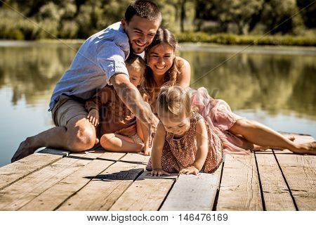Young Family On Pier Near Lake