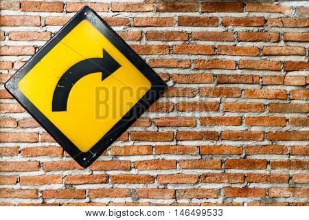 Brick wall with turn right sign on wall