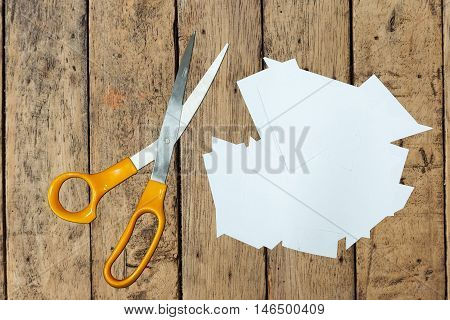 Clear paper cutting and scissors on wood table