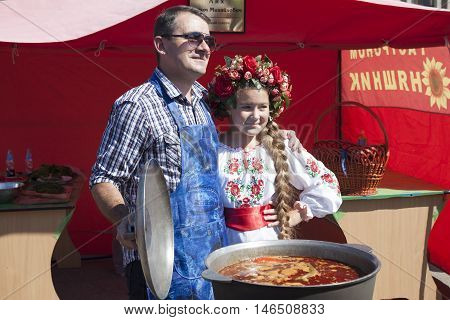 SLOVIANSK UKRAINE - SEPTEMBER 10 2016: Day of Sloviansk. Mayor Vadim M. Lyakh at the Sloviansk Cathedral Square as a chef photographed with an unknown girl in Ukrainian national dress