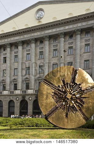 MILAN, ITALY - APRIL 14 2015: Banca Popolare di Milano headquarter with a bronze sculpture by Arnaldo Pomodoro in the foreground