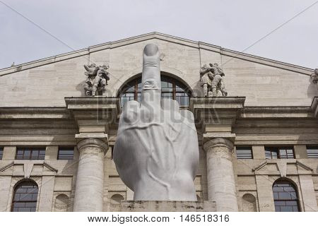 MILAN,  ITALY - APRIL 16 2015: Close up of the controversial sculpture L.O.V.E. by Italian Maurizio Cattelan in front of stock exchange building in Piazza Affari Milan