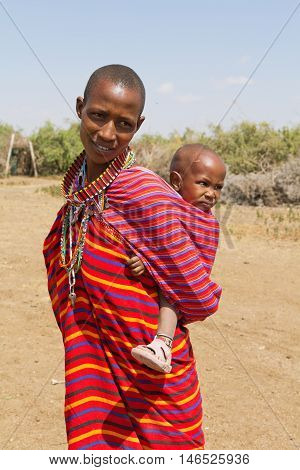 Amboseli Kenya - February 07 2012 - Portrait of masai woman and kid in typical clothing in masai village in Amboseli national park
