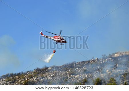 August 21 2016-Monti Prenestini-Castel San Peter- Roma-Lazio-Italy-the helicopter of the fire brigade to put out an arson attack on the slopes Prenestini who is skirting the first inhabited houses