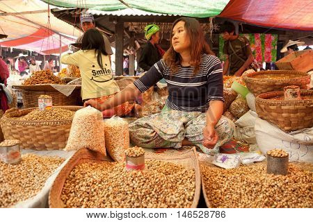 Heho Myanmar - March 02 2011 - Senior Burmese woman selling nuts at the five-day market while sitting on the ground