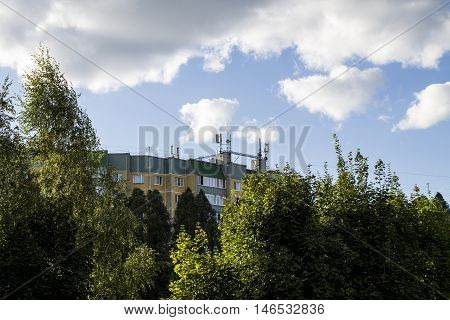 Orange house on a background of trees and sky