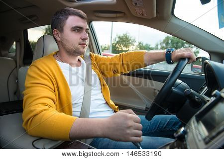 Man driving luxury car. Concept photo of safety driving with seatbelt.