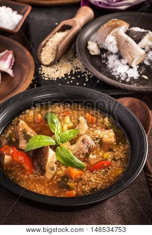 Mushroom quinoa soup in black plate on table