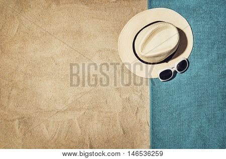 Top view of sandy beach with summer accessories and copy space around products. Blank mock up for advertising or packaging.
