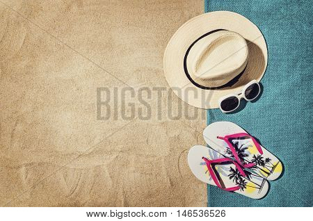 Top view of sandy beach with summer accessories and copy space around products. Blank mock up for advertising or packaging.