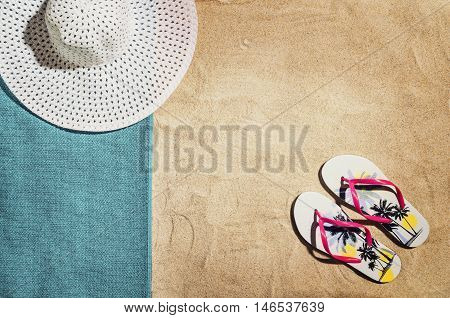 Top view of sandy beach with summer accessories and copy space around products. Blank mock up for advertising or packaging.
