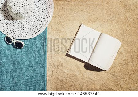 Top view of sandy beach with summer accessories and copy space around products. Blank mock up for advertising or packaging.