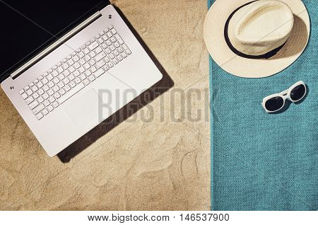 Top view of sandy beach with summer accessories and copy space around products. Blank mock up for advertising or packaging.