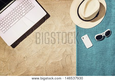 Top view of sandy beach with summer accessories and copy space around products. Blank mock up for advertising or packaging.