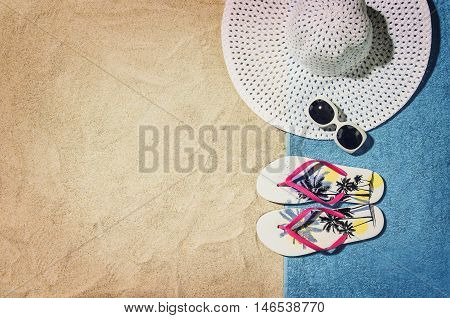 Top view of sandy beach with summer accessories and copy space around products. Blank mock up for advertising or packaging.