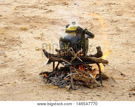 A teapot setting over the fire during a campout.